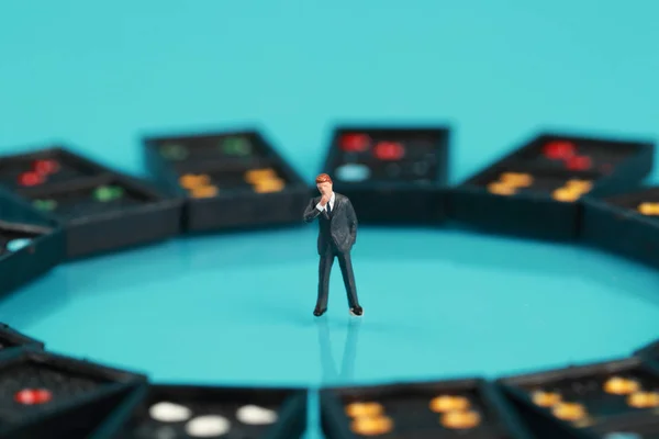 Persone in miniatura: uomo d'affari che si guarda intorno domino e pensa qualcosa (leadership e concetto di business ) — Foto Stock