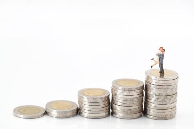 Minyatür insanlar: para yığını üzerinde ayakta bir çift, aşk için tasarruf için fikir