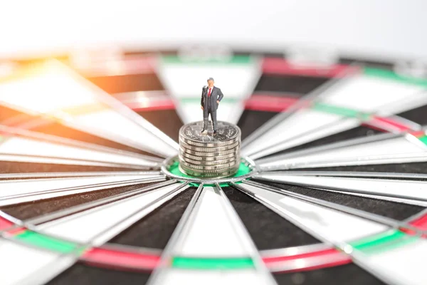 Pessoas em miniatura: homem de negócios em pé no alvo dartboard centro e moeda pódio ideia de goa financeira e de negócios — Fotografia de Stock