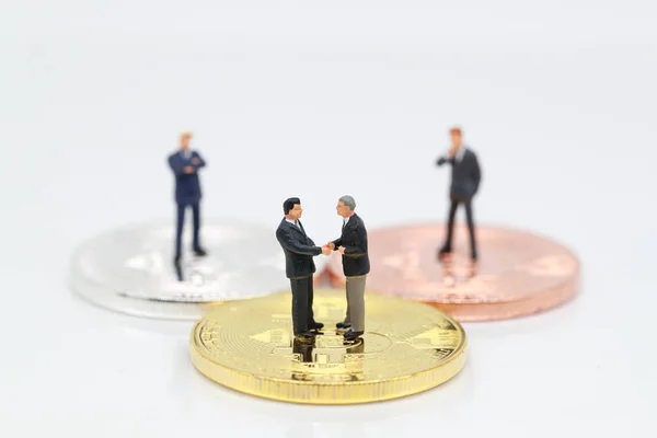Personas en miniatura: un grupo de empresarios de pie en bitcoin (esta imagen para el concepto de competencia financiera y empresarial ) — Foto de Stock