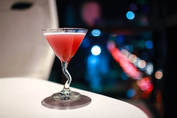 Blur image of cocktail glass with city view at night — Stock Photo, Image