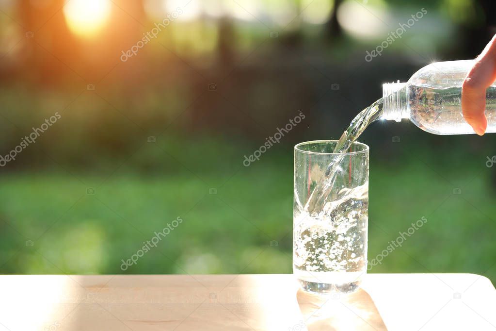 drink water pouring into empty glass with natural green background