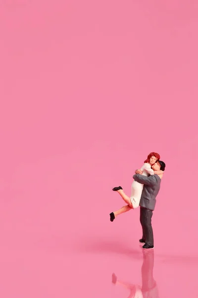 Miniatűr emberek: egy pár állva rózsaszín háttér ötlete szeretet koncepció — Stock Fotó