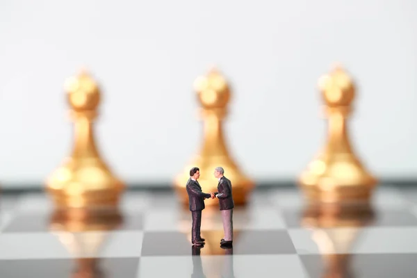 Mãos de empresário movendo o rei do xadrez para a posição de sucesso no  jogo de competição de negócios
