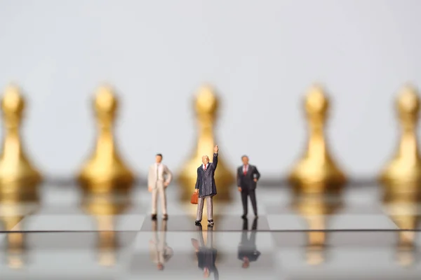 Δουλειά σκακιού με μικροσκοπικούς επιχειρηματίες που έχουν ιδέα για τον ανταγωνισμό, την επιτυχία και την ηγεσία (επιχειρήσεις που χρησιμοποιούν ως φόντο — Φωτογραφία Αρχείου