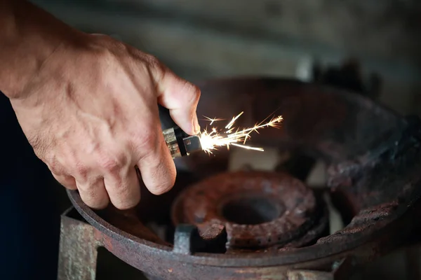 Chiudi la mano tenendo accendino sopra il vecchio gas — Foto Stock