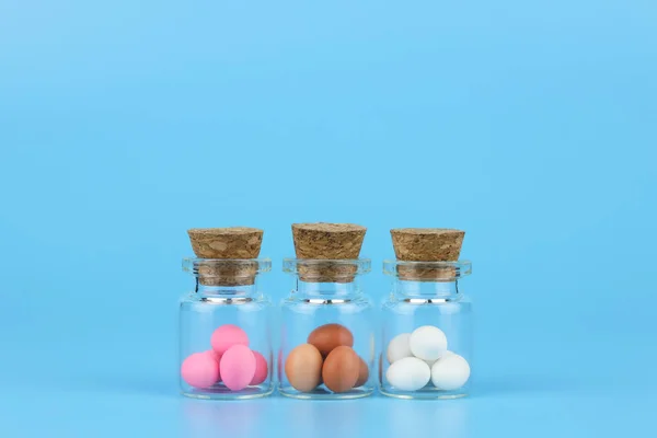 Διακοσμημένα Πασχαλινά αυγά σε φιάλη με μπλε φόντο — Φωτογραφία Αρχείου
