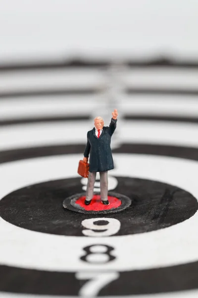 Pessoas em miniatura: homem de negócios em pé no alvo alvo dartboard ideia de objetivo financeiro e de negócios — Fotografia de Stock