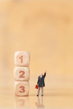 Minyatür insanlar: arka plan olarak kullanarak ahşap podyum ile işadamı ayakta (finansal ve Iş Yarışması kavramı)
