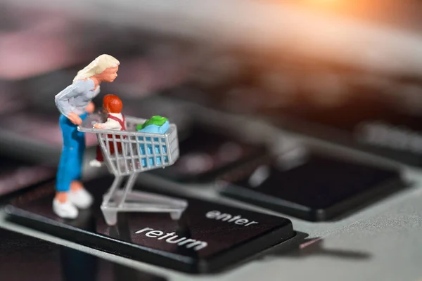 Personas en miniatura: el comprador presiona enter en el teclado del ordenador como pago en línea desde casa (concepto de comercio electrónico y compras ) —  Fotos de Stock