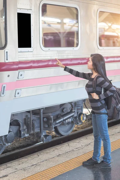 Junge Reisende mit Rucksack checkt Ziel von leerer Computertafel, bevor sie in den Zug steigt — Stockfoto