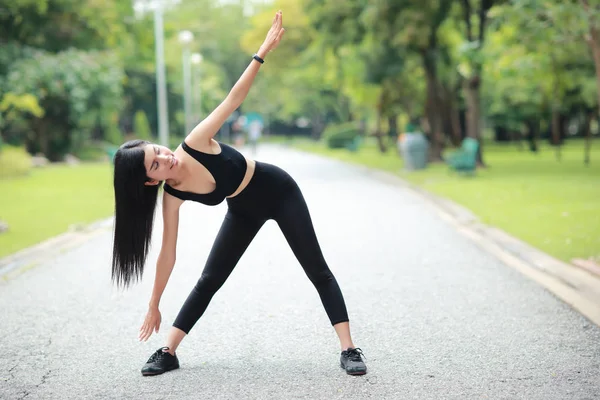 Genç sağlıklı ve sportif kadın açık havada uzanan yoga yapmak — Stok fotoğraf