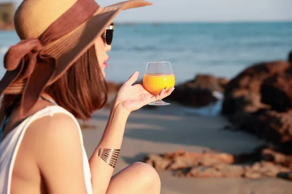 Retrato de mujer hermosa y feliz disfrutar de vacaciones con jugo de naranja en la playa — Foto de Stock