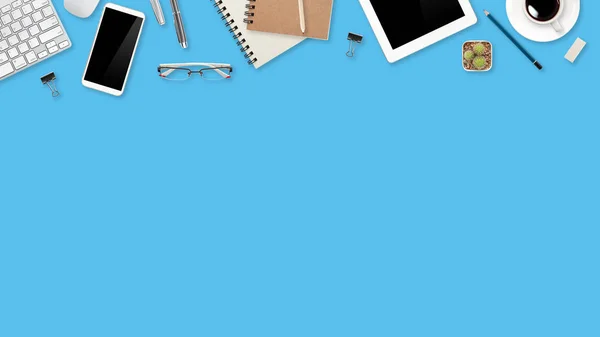 dizüstü bilgisayar, ofis malzemeleri, kahve fincanı, cep telefonu ve mavi pastel arka plan üzerinde kahve fincanı ile çalışma alanı tablo