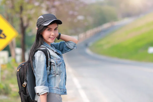 Ung asiatisk reisende med ryggsekk som ser mot veien mens han er på ferie – stockfoto