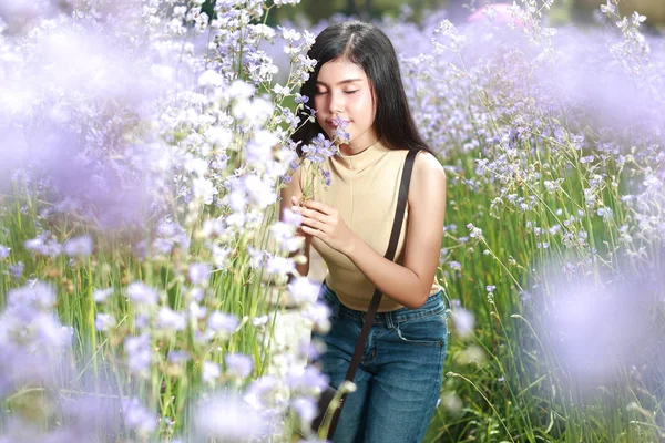 Portrét nádherné ženy, která má šťastné chvíle a baví se mezi květinovými poli Naga-Crested v přírodě — Stock fotografie