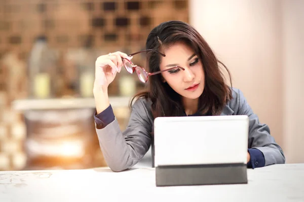 Tablet kullanarak gözlük ile çalışan ve büyüleyici kadın (ev konseptinden iş) — Stok fotoğraf