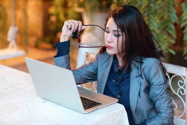 Femme d'affaires mignonne et charmante avec des lunettes de travail sur ordinateur portable du restaurant ou du café — Photo