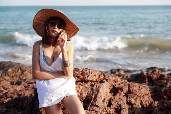 美丽可爱的女商人使用手机与太阳眼镜和帽子在海滩上度假期间 — 图库照片
