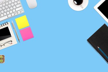 dizüstü bilgisayar, ofis malzemeleri, kahve fincanı, cep telefonu ve mavi pastel arka plan üzerinde kahve fincanı ile çalışma alanı tablo