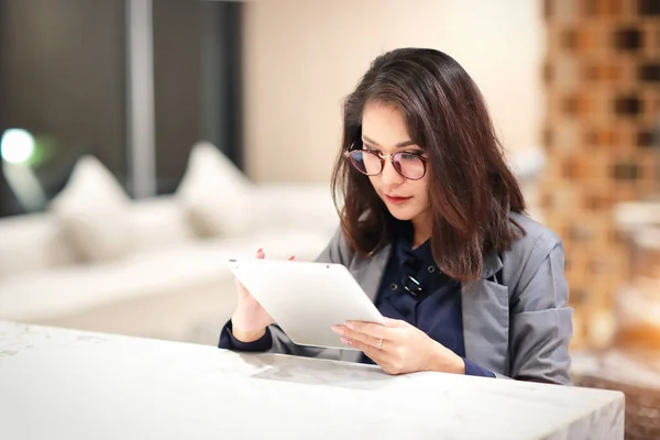 Tablet kullanarak gözlük ile çalışan ve büyüleyici kadın (ev konseptinden iş) — Stok fotoğraf