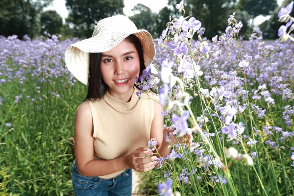 Portrét nádherné ženy, která má šťastné chvíle a baví se mezi květinovými poli Naga-Crested v přírodě — Stock fotografie