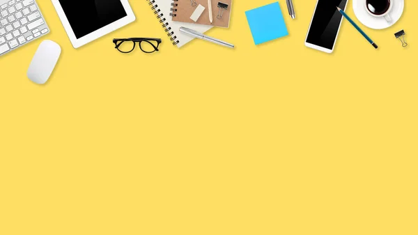 Lapos laikus munkaterület asztal laptop számítógép, irodai kellékek, kávéscsésze, tabletta és mobil telefon sárga pasztell háttér — Stock Fotó