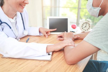 doktor rahatlatıcı , tablet bir şey gösteren ve bakım ile el erkek hasta tutarak (tıbbi kavram)