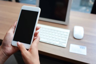 masa ve cep telefonu kullanarak iş kadını elleri