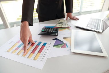 grafik ile şirket özet raporu üzerinde çalışırken tablet ve bilgisayar kullanan iş kadını