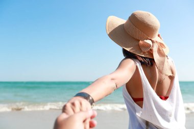 güzel mavi gökyüzü ile plajda el tutan bir çift portresi (tatil tatil konsepti için bu görüntü)