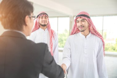 arap suudi işadamı iş geçmişi (takım çalışması ve ortaklık kavramı) kullanarak başarılı bir anlaşma için işadamları ile el sıkışma