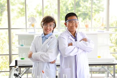 mutlu çocuklar bilim deneyleri yapmak ve kendilerine güvenen ve kişinin kolunu geçerek (eğitim ve bilim adamı kavramı)