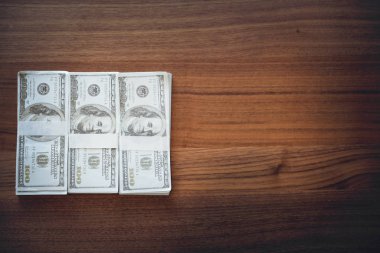 arka plan için kullanarak vintage ahşap masa üzerinde 100 Amerikan doları banknotlar istifleme üst görünümü