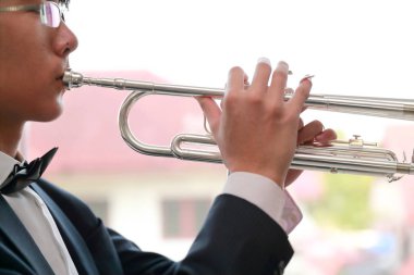 trompet çalan siyah takım elbise giyen genç müzisyen adam yakın