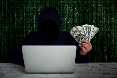 bilgisayar korsanlığı verileri ile siyah kapüşonlu giyen hacker ve yeşil ikili kod arka plan ile yandan para gösteren