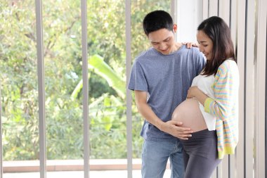 genç asyalı koca kucaklayan ve sevgi ve gülümseme ile genç hamile göbek asya karısı dokunmadan