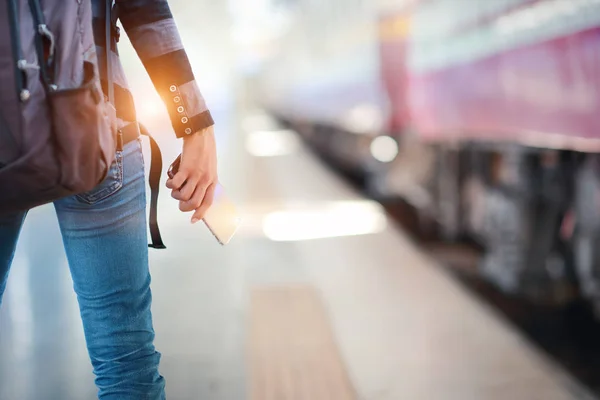 Unge kvinnereisende får smarttelefon fra ryggsekk eller baklommejean – stockfoto