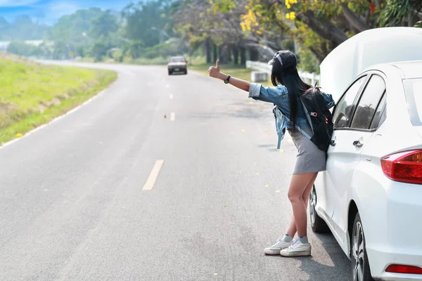 Jovem asiático viajante com mochila e mapa carona na estrada enquanto viaja durante as férias — Fotografia de Stock