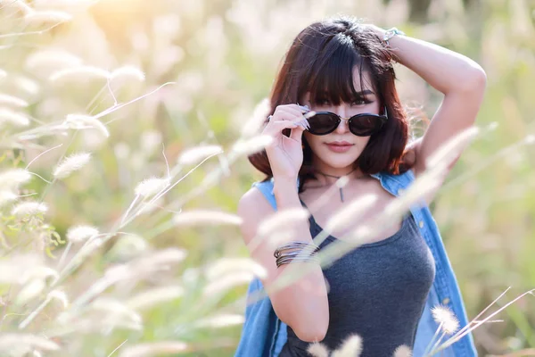 Junges und nettes Mädchen, das eine glückliche Zeit hat und ein Grasfeld in der Natur beneidet — Stockfoto