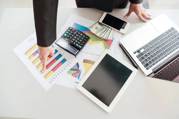 Geschäftsfrau, die Tablet und Computer benutzt, während sie an einem zusammenfassenden Bericht mit Grafik arbeitet — Stockfoto