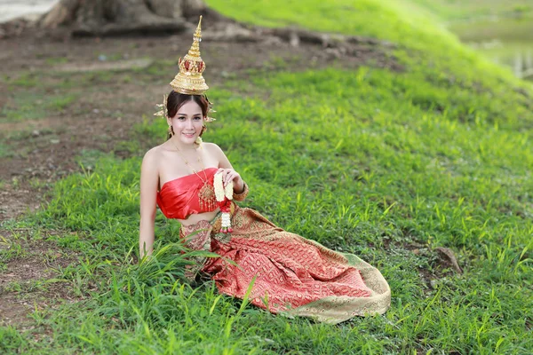 Mode Aziatisch meisje in Thaise traditionele kostuum in oude tempel met stuurwiel bloem in de hand — Stockfoto
