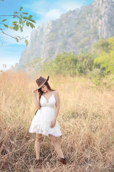 Мила і красива дівчина, що стоїть на природі на відкритому повітрі з капелюхом і обличчям краси — стокове фото