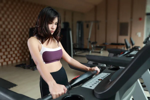 健身馆使用健身机拍摄的年轻健康、健美女子的肖像（此图为健身与锻炼的概念）) — 图库照片