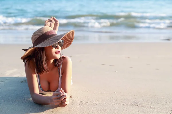Linda e sexy menina asiática com chapéu deitado na praia — Fotografia de Stock