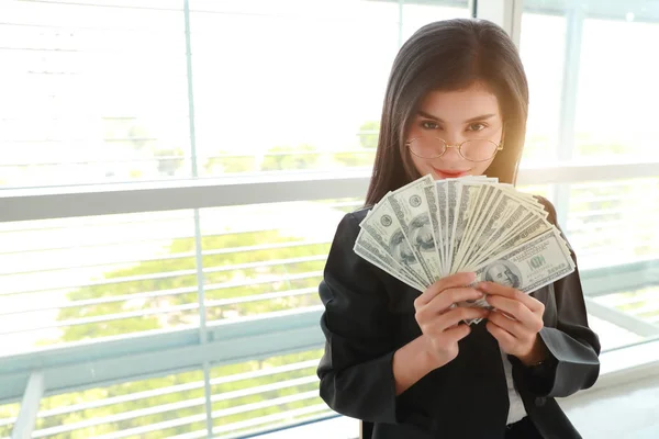 Бізнес-леді показує звіт компанії і графік з грошима на руках — стокове фото