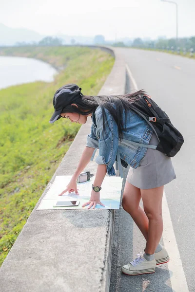 Jovem asiático viajante procurando direção no mapa de localização enquanto viaja durante as férias — Fotografia de Stock