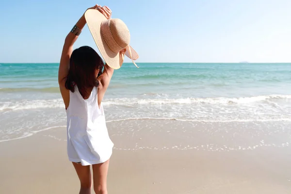 Voltar ver retrato de sexy asiático jovem menina em biquíni e chapéu, olhando para a praia tropical, enquanto em pé na praia de areia na natureza com céu azul . — Fotografia de Stock
