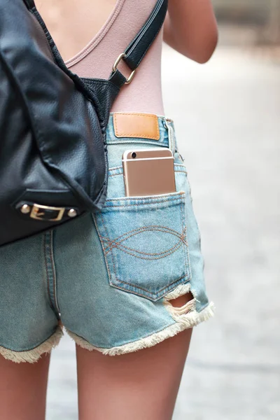 Jovem e bonito menina tem telefone celular no bolso jean — Fotografia de Stock