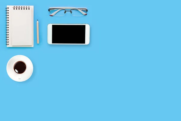 Top view blue pastel office desk with computer, office supplies, cell phone, and black coffee cup — Stock Photo, Image